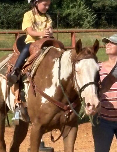 Star student Ila riding Dakota in a lesson with Liz